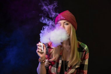 Vaping kız. Genç hipster kadın vape e-cig studio siyah arka plan üzerinde. Hip-hop tarzı. Yakın çekim.