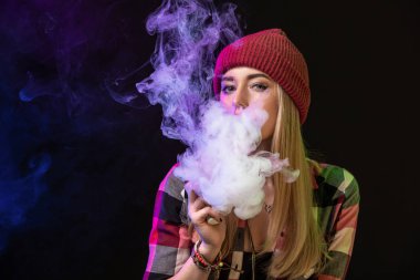 Vaping kız. Genç hipster kadın vape e-cig studio siyah arka plan üzerinde. Hip-hop tarzı. Yakın çekim.