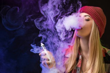 Vaping kız. Genç hipster kadın vape e-cig studio siyah arka plan üzerinde. Hip-hop tarzı. Yakın çekim.
