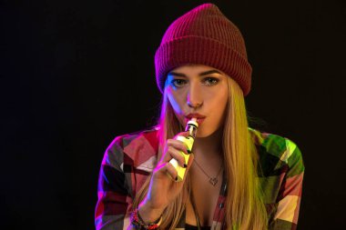 Vaping kız. Genç hipster kadın vape e-cig studio siyah arka plan üzerinde. Hip-hop tarzı. Yakın çekim.