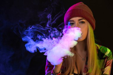 Vaping kız. Genç hipster kadın vape e-cig studio siyah arka plan üzerinde. Hip-hop tarzı. Yakın çekim.