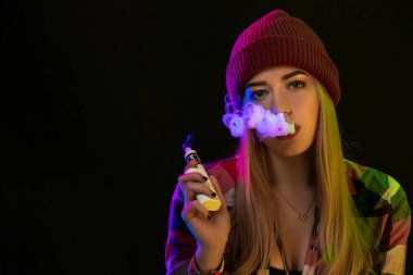 Vaping kız. Genç hipster kadın vape e-cig studio siyah arka plan üzerinde. Hip-hop tarzı. Yakın çekim.