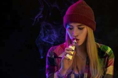 Vaping kız. Genç hipster kadın vape e-cig studio siyah arka plan üzerinde. Hip-hop tarzı. Yakın çekim.