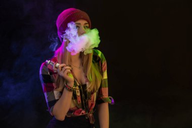 Vaping kız. Genç hipster kadın vape e-cig siyah arka plan üzerine. Hip-hop tarzı. Stüdyo vurdu