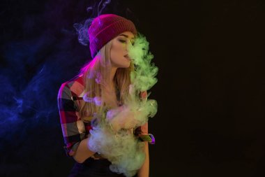 Vaping kız. Genç hipster kadın vape e-cig siyah arka plan üzerine. Hip-hop tarzı. Stüdyo vurdu