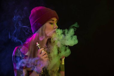 Vaping kız. Genç hipster kadın vape e-cig siyah arka plan üzerine. Hip-hop tarzı. Stüdyo vurdu