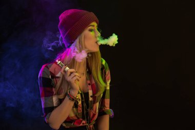 Vaping kız. Genç hipster kadın vape e-cig siyah arka plan üzerine. Hip-hop tarzı. Stüdyo vurdu