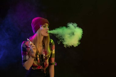 Vaping kız. Genç hipster kadın vape e-cig siyah arka plan üzerine. Hip-hop tarzı. Stüdyo vurdu
