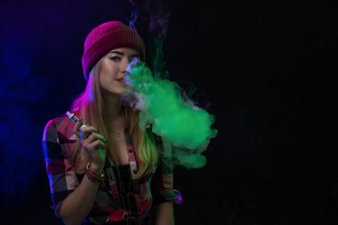 Vaping kız. Genç hipster kadın vape e-cig siyah arka plan üzerine. Hip-hop tarzı. Stüdyo vurdu