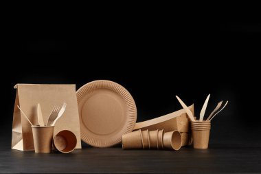 Çevre dostu tek kullanımlık sofra takımı siyah arka planda duruyor. Biyo-çözünebilir el yapımı yemekler. Geri dönüşüm konsepti. Yakın çekim..