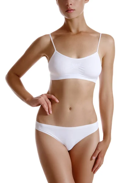 Perfekt, smal, tonad, ung kropp av en flicka i vita underkläder poserar isolerad på vitt. Plastikkirurgi och estetisk kosmetologi koncept. Närbild. — Stockfoto