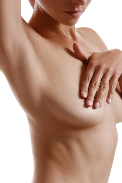 Perfekt, naken kropp av en flicka som täcker sitt bröst med händer, poserar isolerad på vitt. Plastikkirurgi och estetisk kosmetologi koncept. Närbild. — Stockfoto