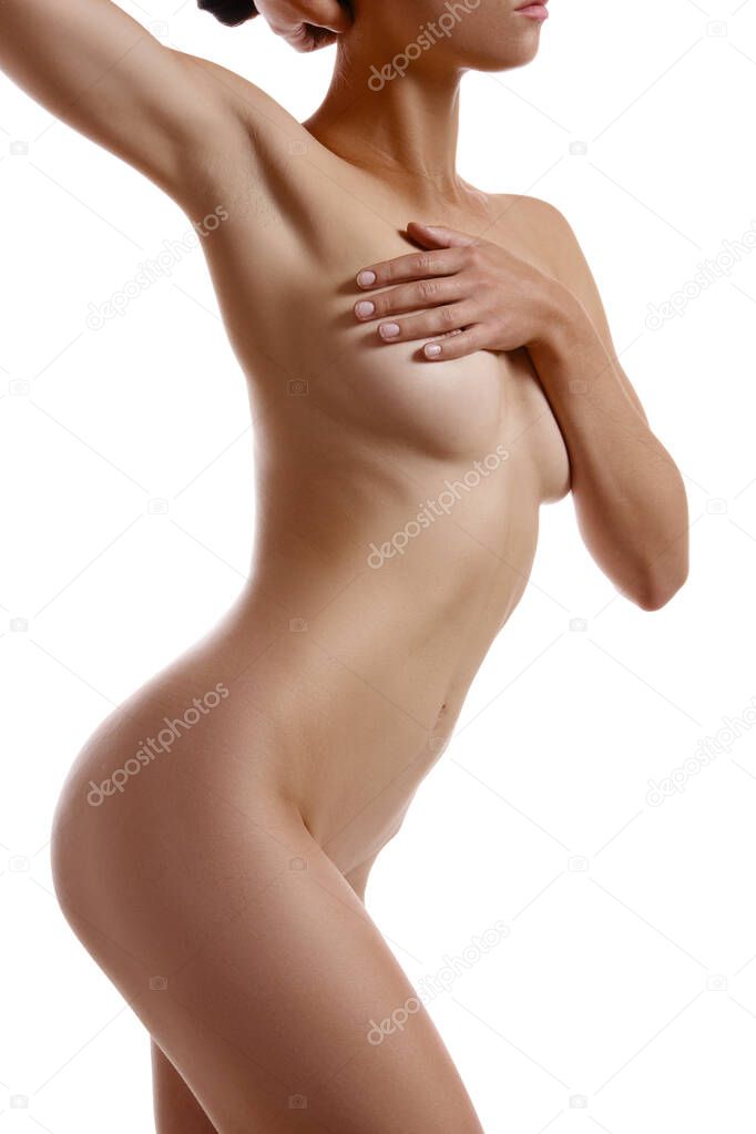 Perfect, nude body of a girl covering her breast with hands posing isolated on white. Plastic surgery and aesthetic cosmetology concept. Close-up.