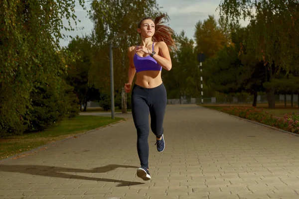 लड़की एथलीट सुबह बाहर दौड़ रहा है, शहर में, पेड़ों से घिरा एक पार्क पथ पर। सक्रिय स्वस्थ जीवन शैली। खेल और मनोरंजन अवधारणा . — स्टॉक फ़ोटो, इमेज