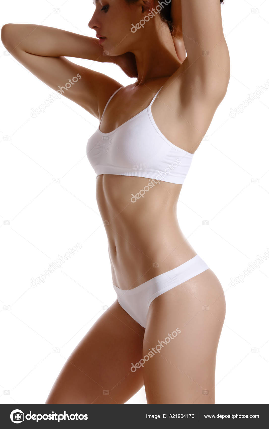 Perfect, slim, toned, young body of a girl in white underwear posing  isolated on white. Plastic surgery and aesthetic cosmetology concept.  Close-up. Stock Photo by ©nazarov.dnepr@gmail.com 321904176