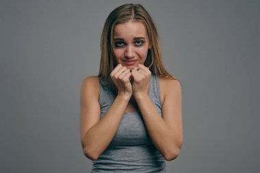 Yüzünde morluklar olan sarışın kız gri stüdyo arka planında poz veriyor. Aile içi şiddet, taciz. Depresyon, umutsuzluk. Yakın plan, kopyalama alanı.