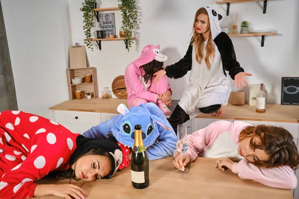 Lányok öltözött plüss pizsama formájában rajzfilmek karakterek élvezi tyúk-party. Néhányan berúgtak, elaludtak a konyhapadlón. Közelkép — Stock Fotó