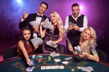 Bir grup zengin genç iş arkadaşı kumarhanede poker oynuyor. Gençler büyük bir galibiyet için bahis oynuyorlar. Gülümsüyorlar ve masada siyah duman arka planında kırmızı ve mavi arka farlara karşı biraz para tutuyorlar. Kartlar, çipler, para