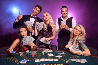 Bir grup zengin sınıf arkadaşı kumarhanede poker oynuyor. Gençler büyük bir galibiyet için bahis oynuyorlar. Masada siyah dumanlı kırmızı ve mavi arka farlara karşı poz vererek gülümsüyorlar. Kartlar, fişler, para, kumar, eğlence