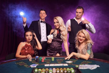 Bir grup zengin sınıf arkadaşı kumarhanede poker oynuyor. Gençler büyük bir galibiyet için bahis oynuyorlar. Masada siyah dumanlı kırmızı ve mavi arka farlara karşı poz vererek gülümsüyorlar. Kartlar, çipler, para, kumar, eğlence 