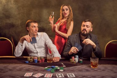 İki yakışıklı arkadaş ve seksi kadın kumarhanede poker oynuyorlar. Büyük bir galibiyet için iddiaya giriyorlar ve masada arka plandaki sarı ışığa karşı poz verirken iyi vakit geçiriyorlar. Kartlar, fişler, para, kumar, eğlence