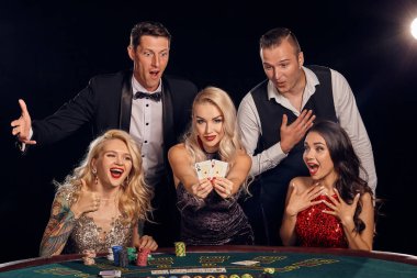 Şık ve zengin bir grup kumarhanede poker oynuyor..