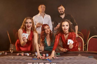 Bir grup hoş arkadaş kumarhanede poker oynuyorlar. Kazanışlarını kutluyorlar, kameraya bakıyorlar ve ellerinde oyun kartları tutuyorlar. Masada dumanlı bir arka planda poz veriyorlar. Çipler, para, alkol, kumar, ent