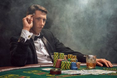 Siyah takım elbiseli ve beyaz gömlekli zeki bir adam kumarhanede beyaz bir spot ışığına karşı duman içinde poker oynuyor. Puro içerek kazandığı için seviniyor ve birine bakıyor. Kumar bağımlılığı. Samimi duygular ve eğlence.
