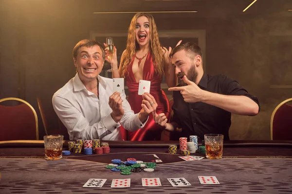 Grupo de jóvenes amigos ricos están jugando al póquer en un casino . — Foto de Stock