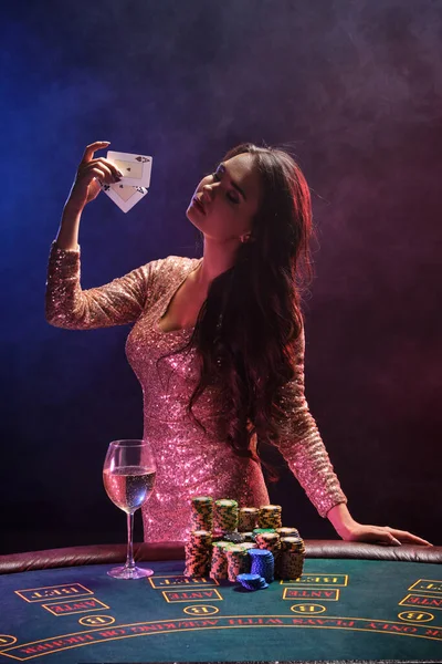 Brunette girl with a perfect hairstyle and bright make-up is posing with playing cards in her hands. Casino, poker. — Stock Photo, Image