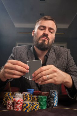Klasik takım elbiseli sakallı bir adam, bir sürü fiş ile kumarhanede poker oynuyor. Büyük bir galibiyet için bahisler oynuyor. Para için kumar oynuyorum. Şans oyunları..