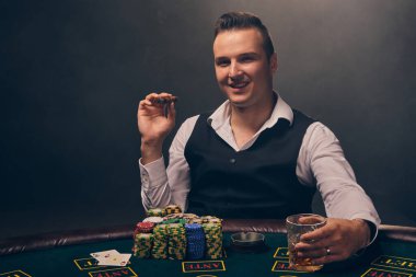 Beyaz gömlekli ve siyah yelekli zengin bir adam elinde bir puro ve bir bardak viski tutuyor. Kumarhanede siyah arka planda bir ışık hüzmesiyle poker oynuyor. İskambil kağıtlarıyla riskli kumar eğlencesi ve 