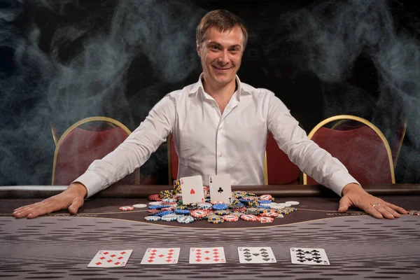 Ενθουσιασμένος Χαμογελαστός Άνθρωπος Ένα Λευκό Πουκάμισο Παίζει Πόκερ Κάθεται Στο — Φωτογραφία Αρχείου