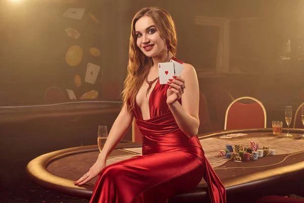 Detailní záběr krásné ženy pózující proti pokerovému stolu v luxusním kasinu. — Stock fotografie