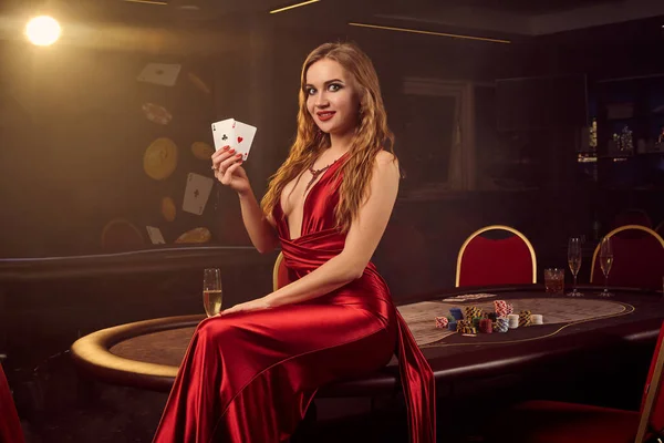 若い美しい女性は高級カジノのポーカーテーブルに対してポーズをとっています. — ストック写真