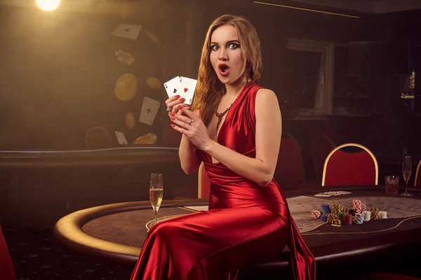 若い美しい女性は高級カジノのポーカーテーブルに対してポーズをとっています. — ストック写真
