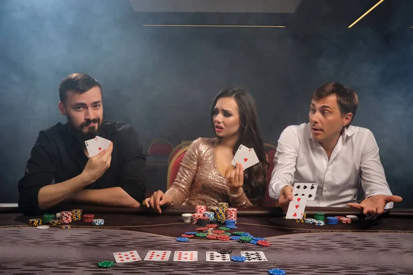 Skupina mladých bohatých přátel hrají poker v kasinu. — Stock fotografie