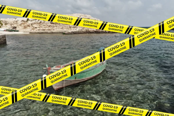 Biohazard Coronavirus warning tapes against seascape of Polignano a Mare with cliffs and boat in transparent water of the Adriatic Sea. Bari, Puglia, Italy. Quarantine. Pandemic COVID-19