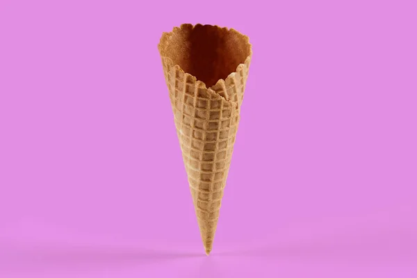 Empty, sweet wafer cone for ice cream against pink background. Concept of food and treats. Mockup, template for your advertising and design. Close up, copy space