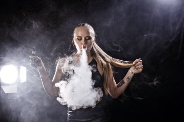 Kız bir siyah arka plan vape yükselir