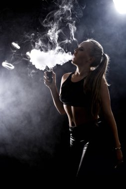 Kız bir siyah arka plan vape yükselir