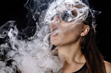 Kız bir siyah arka plan vape yükselir