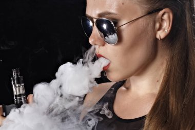 Kız bir siyah arka plan vape yükselir