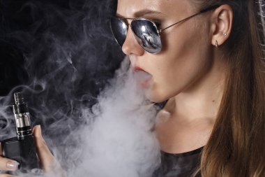Kız bir siyah arka plan vape yükselir