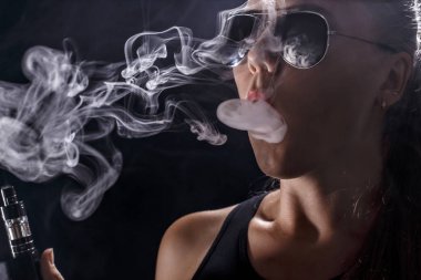 Kız bir siyah arka plan vape yükselir