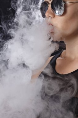 Kız bir siyah arka plan vape yükselir
