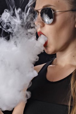 Kız bir siyah arka plan vape yükselir