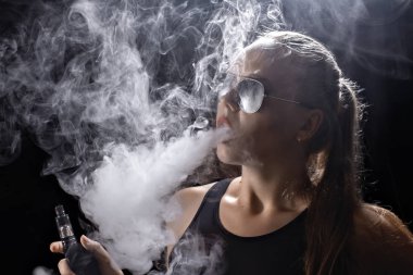 Kız bir siyah arka plan vape yükselir