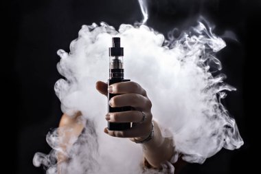 Kız bir siyah arka plan vape yükselir