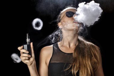 Kız bir siyah arka plan vape yükselir